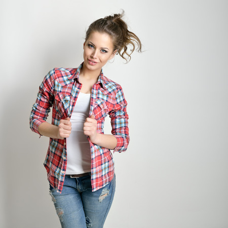 Beautiful teen girl with jeans and checkd shirt. Fashion girl.の写真素材