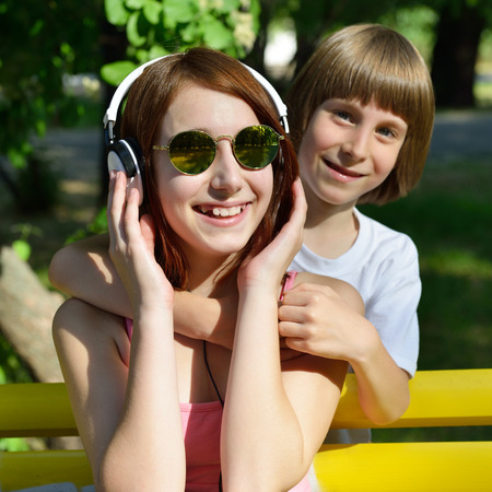Boy and teen girl have fun outdoor in summer park. Happy children.の写真素材