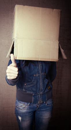 faceless girl with box on her head LIKE with thumb up, social network concept, toned