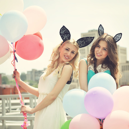 Happy romantic fashion girls with colorful balloons, outdoors. Toned.の写真素材