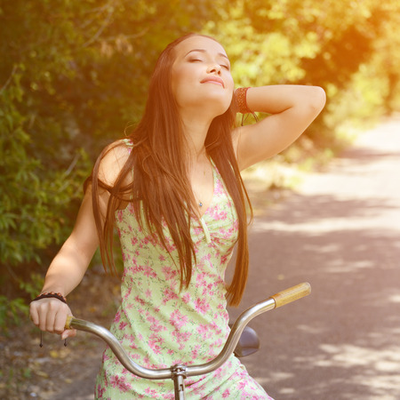 Happy smiling young beautiful woman with retro bicycle, summer outdoor, image tonedの写真素材