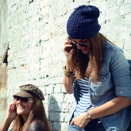 Girls having fun together outdoors and calling smart phone, lifestyle. の写真素材