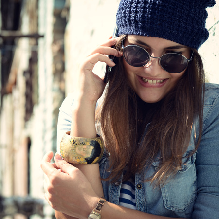 Girl having fun outdoors calling smart phone, lifestyle. Toned.の写真素材