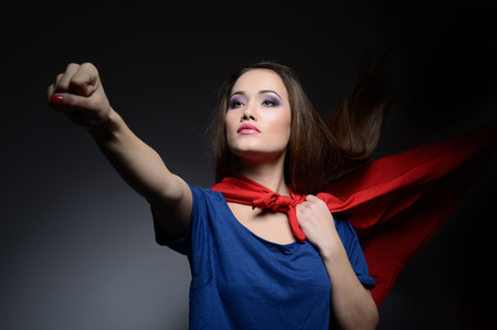 Superwoman. Young pretty woman opening her shirt like a superhero. Super girl, image toned. Beauty saves the world.の写真素材