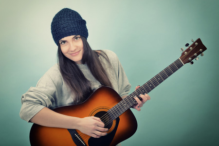 young woman playing music on acoustic guitar, tonedの写真素材