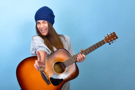 young woman playing music on acoustic guitar