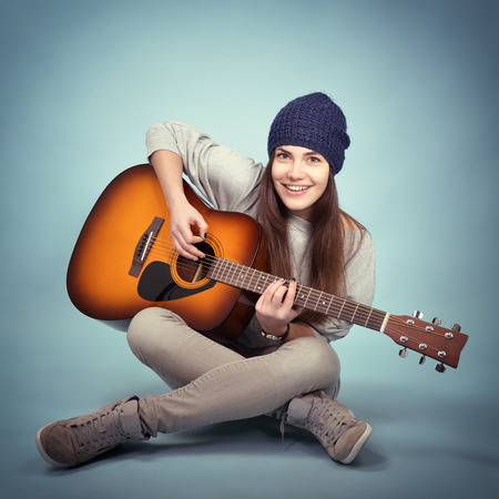 young woman playing music on acoustic guitar, tonedの写真素材