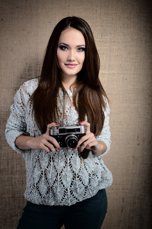 Photographer woman holding retro camera and taking photos, tonedの写真素材