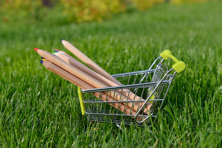 mini shopping cart with pencils outdoorの写真素材