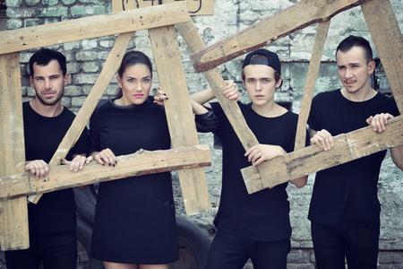Music band outdoor portrait. Musicians posing outside against grunge wall, image toned and noise added.の写真素材