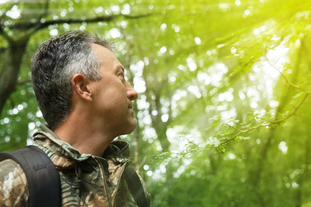 Outdoor autumn male portrait. Handsome middle-aged man posing in forest, image toned and noise added.の写真素材