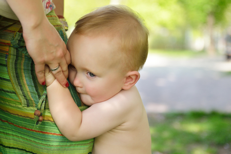 Happy mother holding her adorable little son. Family outdoor leisure. Little kid with his mom playing in park, image toned, soft focusの写真素材