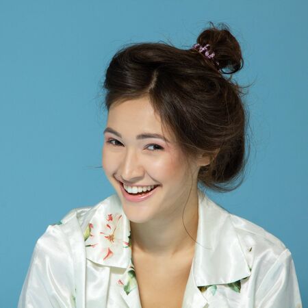 Cheerful attractive sleepy teen girl wearing pyjamas looking at camera like at mirror in the...