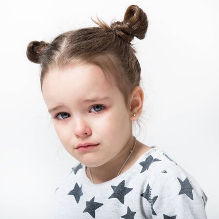 Crying little girl. Upset kid. Sad kid portrait. Cute little girl crying and does not want to go in bed at nightの写真素材