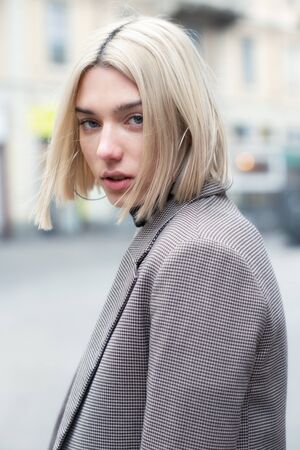 Outdoor urban female portrait, soft focus. Fashion model. Young woman posing in Milan streets. Beautiful caucasian girl with blond hair walking in city.の写真素材