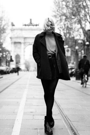 Outdoor urban female portrait, black and white. Fashion model. Young woman posing in Milan streets against Arch of Peace (Arco della Pace).の写真素材