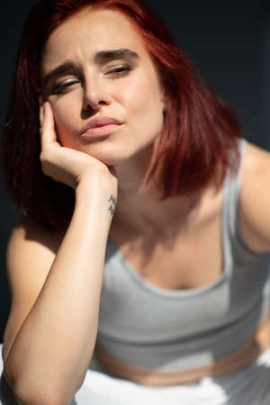 Beautiful young ginger woman. Black and white portrait of charming girl wearing casual clothes posing at homeの写真素材