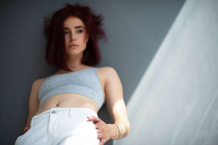 Beautiful young ginger woman with freckles and blue eyes. Portrait of charming girl wearing casual clothes posing at home, looking at cameraの写真素材