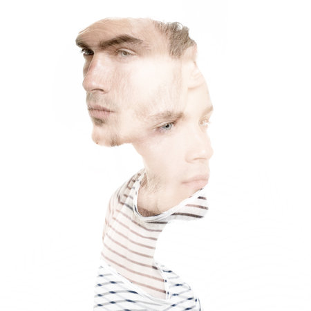 Double exposure portrait of young man, studio shot over black background.の写真素材