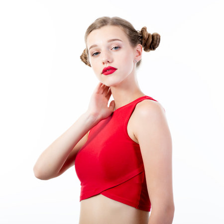Young charming woman wearing red top posing at studio over white backgroundの写真素材