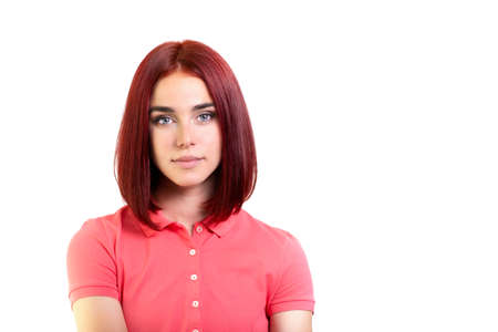 Beautiful young woman with ginger hair and pink t-shirt looking at camera isolated over white background.の写真素材