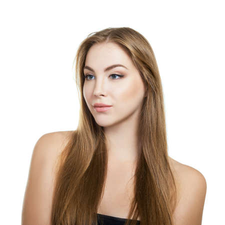 Young attractive woman with perfect make-up and long fair hair posing at studio over white background, beauty female portrait.の写真素材