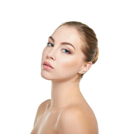 Young attractive woman with perfect make-up posing at studio over white background, beauty female portrait.の写真素材