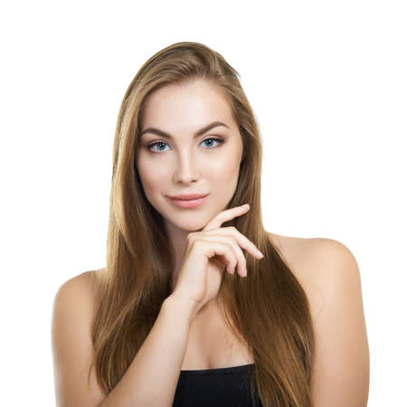 Young attractive woman with perfect make-up and long fair hair posing and smiling at studio over white background, beauty female portrait.の写真素材