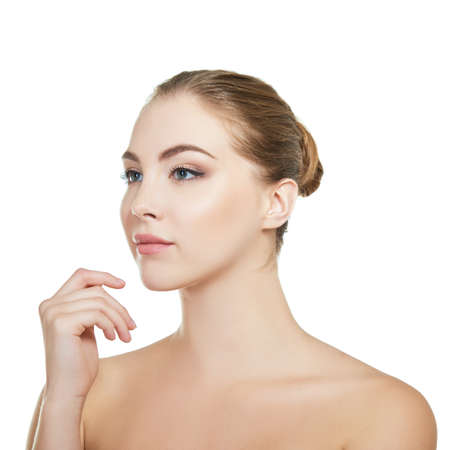 Young attractive woman with perfect make-up posing at studio over white background, beauty female portrait.の写真素材