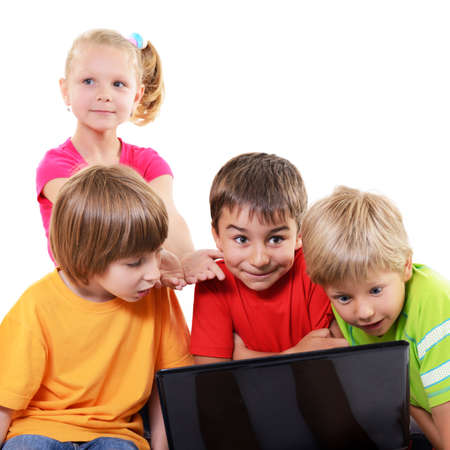 A group of primary school children with interest look at the monitor screen, isolated on white backgroundの写真素材