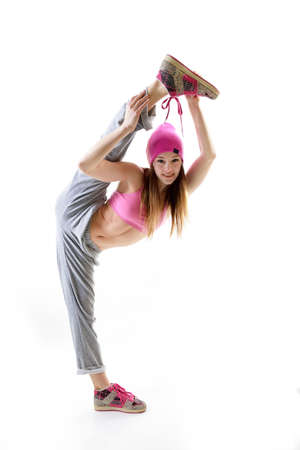 Young girl dancing hip-hip in streetwear at studio on a white backgroundの写真素材
