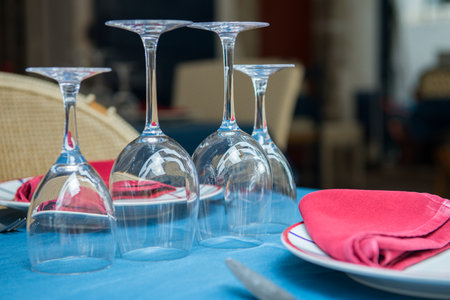 Plates, glasses and cutlery are on the tables and waiting for visitors in outdoor French cafe, Saint-Jean de Luz, detailの写真素材