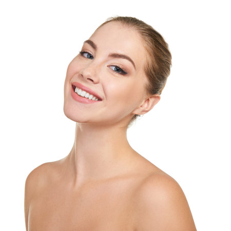 Young attractive woman posing at studio and happy smiling over white background. Beautiful girl with perfect smile.の写真素材