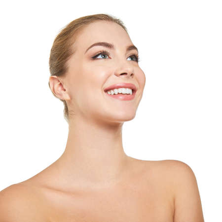 Young attractive woman posing at studio and happy smiling over white background. Beautiful girl with perfect smile.の写真素材