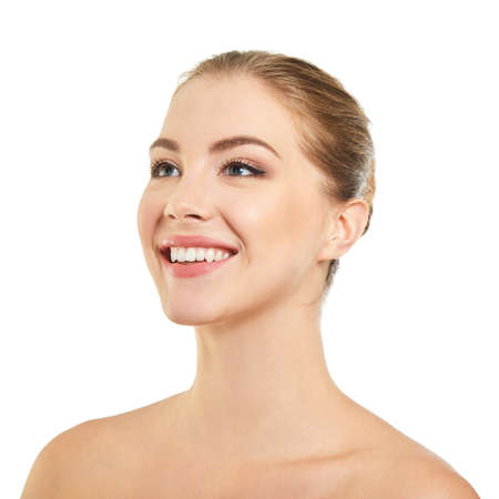 Young attractive woman posing at studio and happy smiling over white background. Beautiful girl with perfect smile.の写真素材
