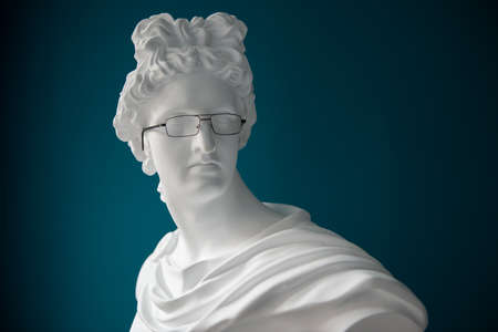Plaster statue head with glasses. Antiquity and modernity. Myopia and hyperopia treatment conceptの写真素材