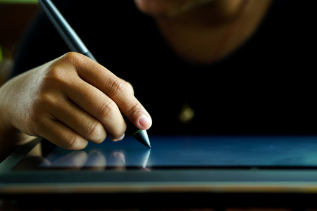 Close up Hands with pen writing on the modern graphic tablet