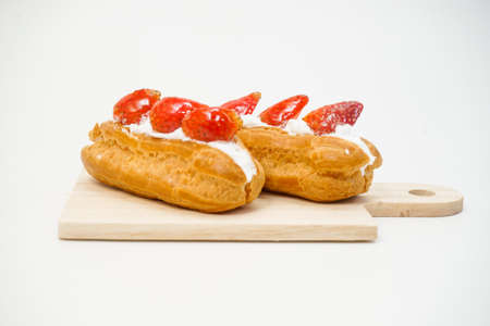 Cream puffs with strawberries slices cake on white background