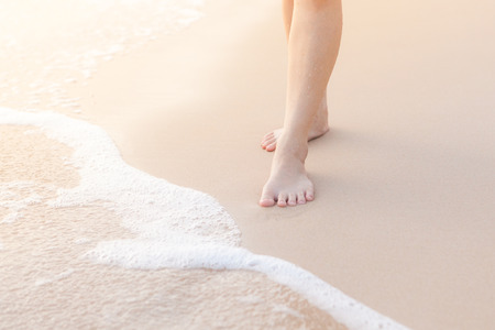 Female legs stand at the beachの写真素材
