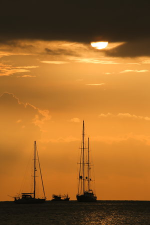 Silhouette boat on the sea sunset momentの写真素材