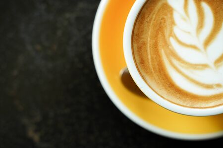 Coffee Latte leaf pattern face on black tableの写真素材
