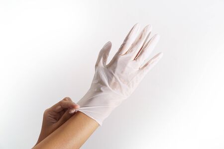 Woman hands wering rubber glove protection safety covid 19 white backgroundの写真素材