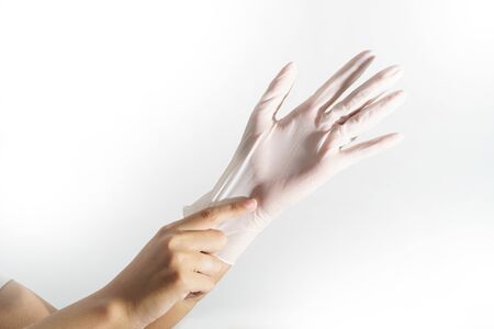 Woman hands wering rubber glove protection safety covid 19 white backgroundの写真素材