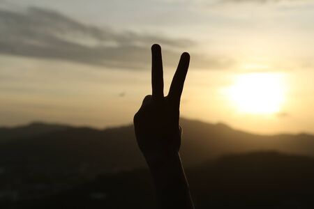 two fingers hand language with scenery backgroundsの写真素材