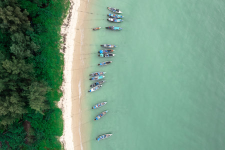 Fisherman long tail boat at shore beach aerial top view greenery tree blue seaの写真素材