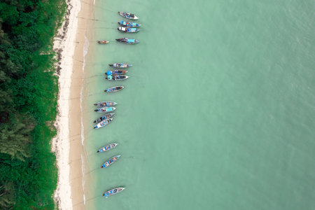 Fisherman long tail boat at shore beach aerial top view greenery tree blue seaの写真素材
