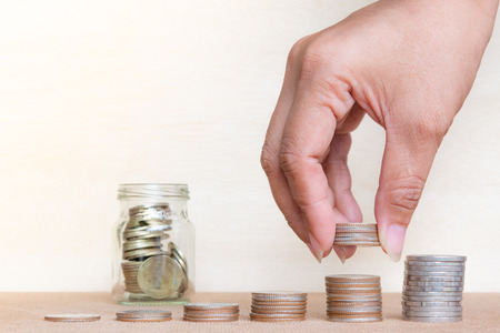 Saving money concept. Finger hold stack coins to arrangement with shown concept of growing business...