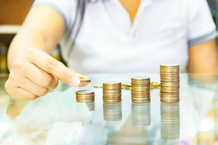 Saving money concept preset by Male hand putting money coin stack growing business.の写真素材
