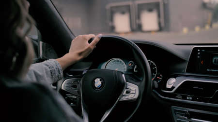TOMSK, RUSSIA - July 26, 2019: Blonde Girl driving a BMW 7 Series. Type of interior. Location cityのeditorial素材