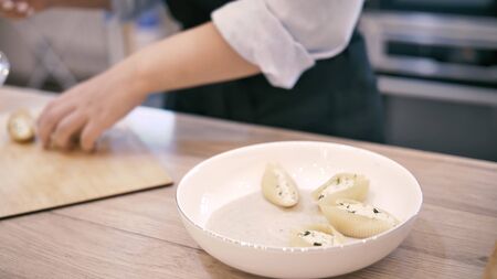 Chef serves a beautiful dish on a plate of Italian ravioli